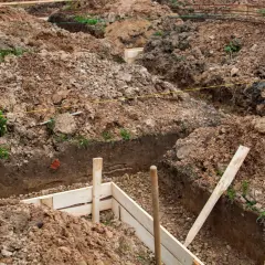 Wykopy pod fundamenty, przygotowane do wylania betonu. Zastanawiasz się, ile kosztuje kopanie fundamentów? To kluczowy etap budowy.
