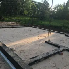 Płyta fundamentowa przygotowana do zimowania. Jak zabezpieczyć płytę fundamentową na zimę? Widać zbrojenie i piasek.