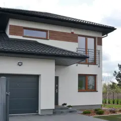 Nowoczesne domy drewniane bliźniaki z białym tynkiem i brązowymi akcentami, zadaszonym garażem i metalową bramą.