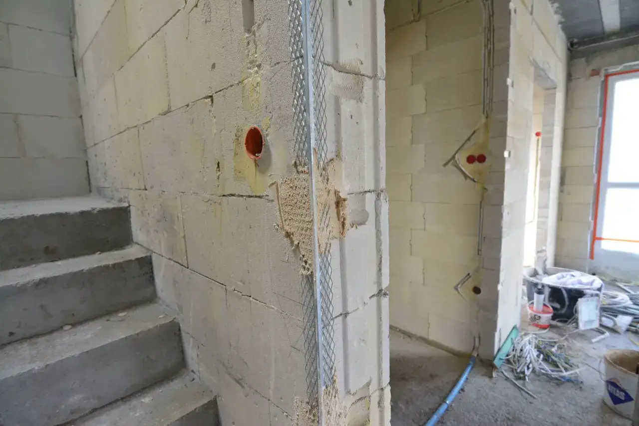 Stan surowy zamknięty co dalej? Betonowe schody, ściany z bloczków, instalacja elektryczna i materiały budowlane czekają na dalsze prace.